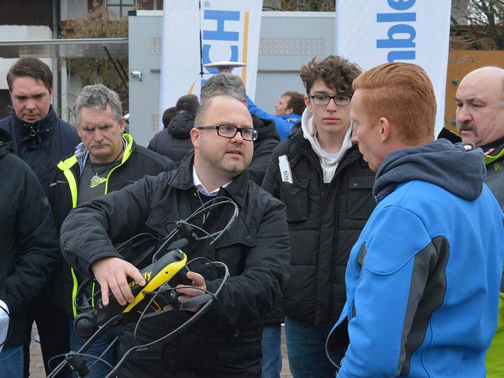 Interessiert verfolgen die Besucher die Vermessung durch UAV-SenseFly Drohnen und Copter auf dem Außengelände